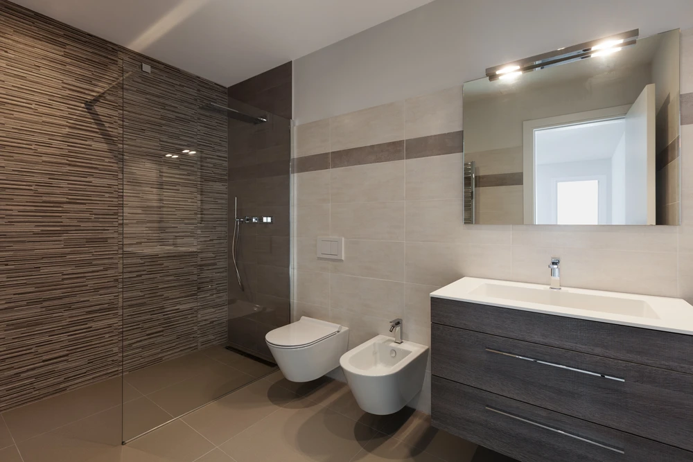 Salle de bain moderne avec douche à l'italienne vitrée et vasque à poser sur meuble suspendu en bois